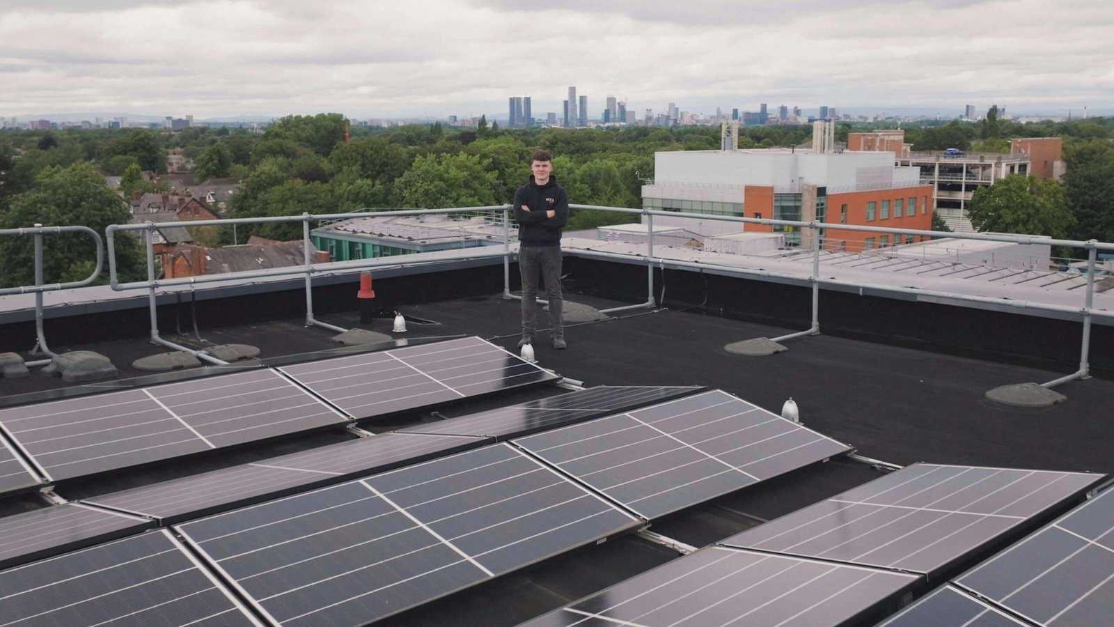 um homem no telhado do prédio com placa solar